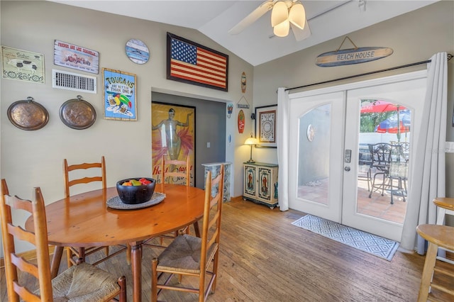 dining area with wood-type flooring, vaulted ceiling, ceiling fan, and french doors