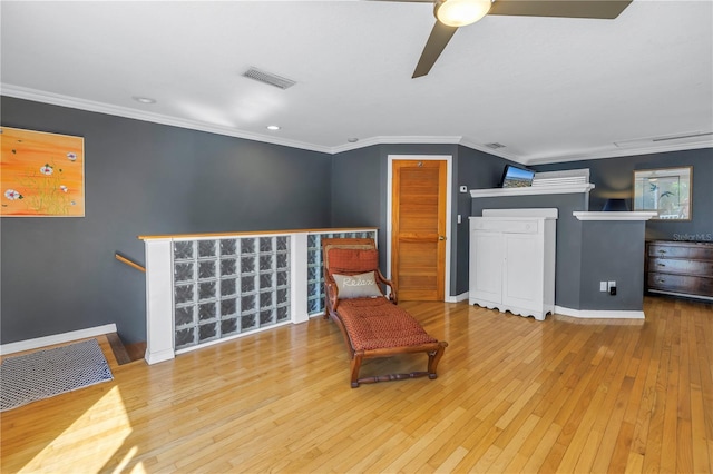 sitting room with wood-type flooring, ceiling fan, and crown molding