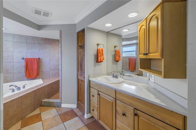 bathroom featuring vanity, tiled tub, crown molding, and tile patterned floors