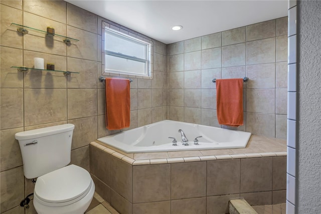 bathroom with tile walls, tiled bath, and toilet