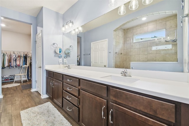 bathroom with tiled shower and vanity