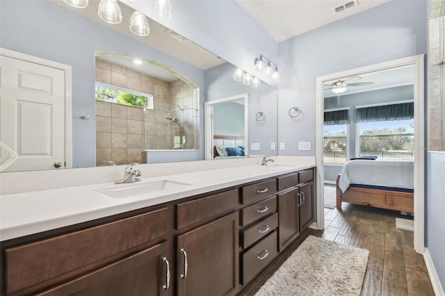 bathroom featuring hardwood / wood-style flooring, tiled shower, plenty of natural light, and vanity