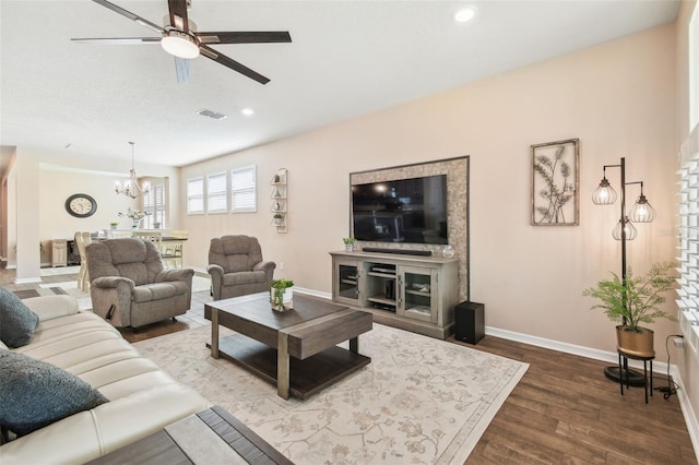 living room featuring wood-type flooring and ceiling fan with notable chandelier