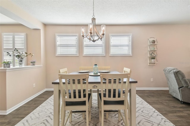 dining room featuring dark hardwood / wood-style floors, a chandelier, and a textured ceiling