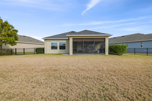 back of house with a lawn and a sunroom