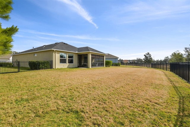 back of house featuring a sunroom and a lawn