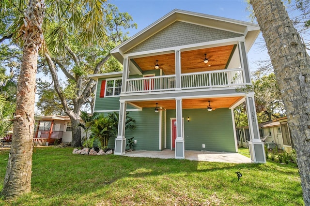 rear view of house with a balcony, a patio area, ceiling fan, and a lawn