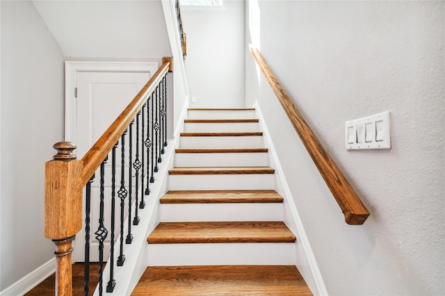 stairs featuring hardwood / wood-style floors