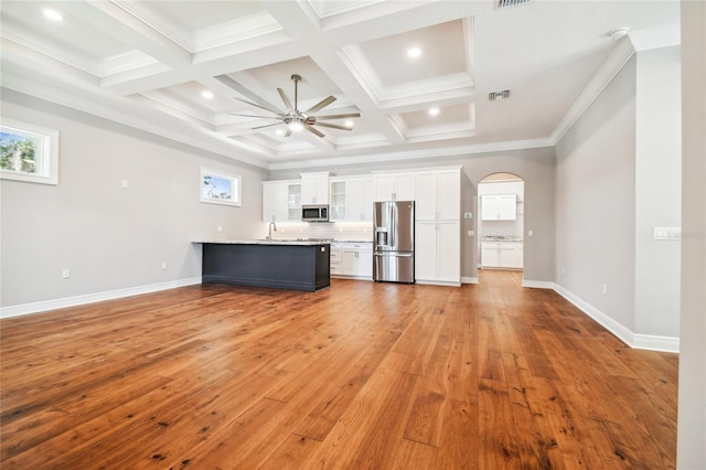 unfurnished living room with ceiling fan, coffered ceiling, sink, and light wood-type flooring