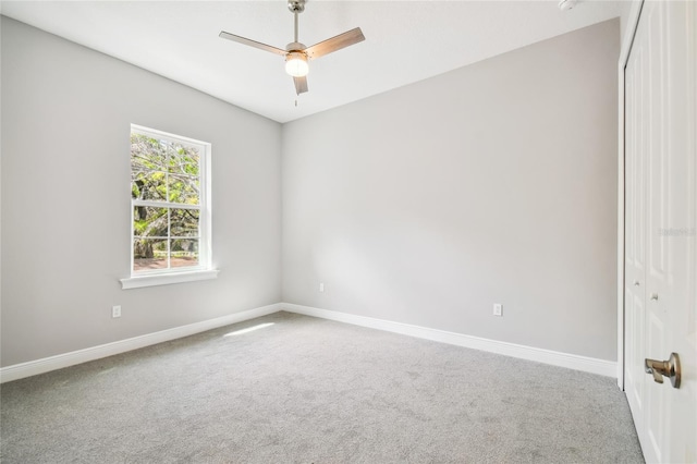 empty room with ceiling fan and carpet flooring