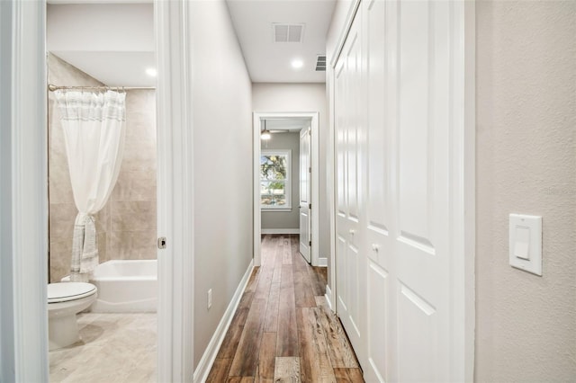 hallway with hardwood / wood-style floors