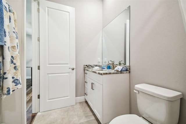 bathroom featuring vanity, tile patterned floors, and toilet