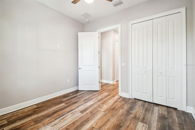 unfurnished bedroom with hardwood / wood-style floors, a closet, and ceiling fan