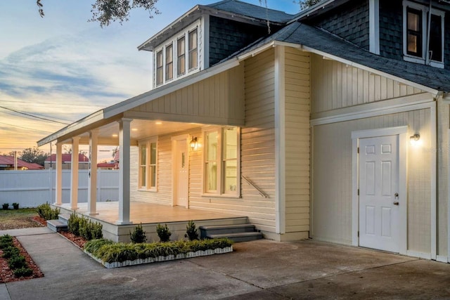 back house at dusk with covered porch