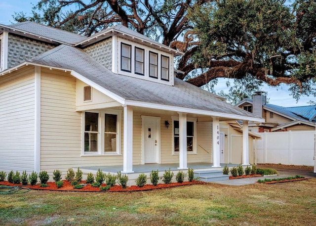 view of front of house with covered porch and a front lawn