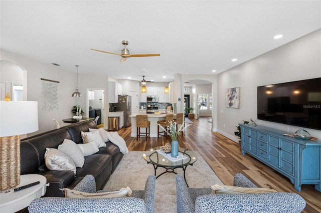 living room with ceiling fan and light wood-type flooring