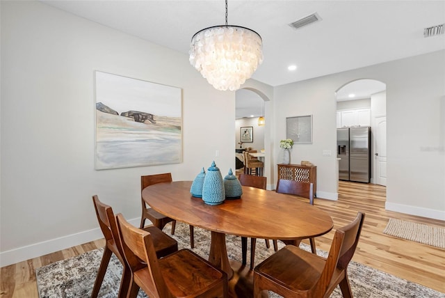 dining room featuring an inviting chandelier and light hardwood / wood-style flooring