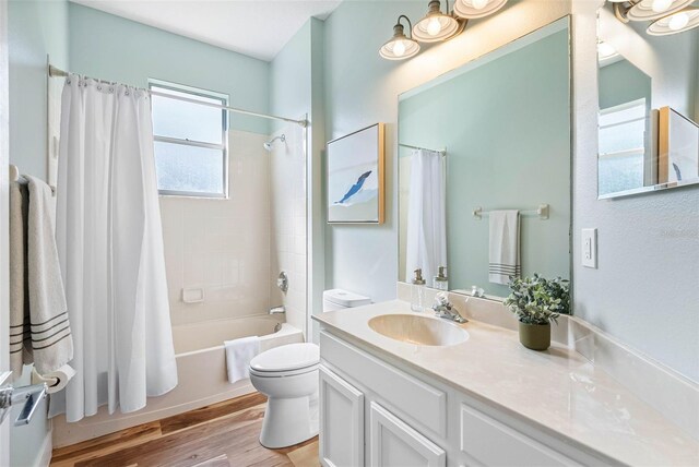 full bathroom with vanity, hardwood / wood-style flooring, toilet, and shower / bath combo with shower curtain