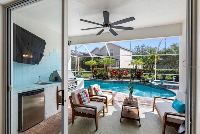 view of pool featuring a patio, sink, exterior kitchen, an in ground hot tub, and grilling area