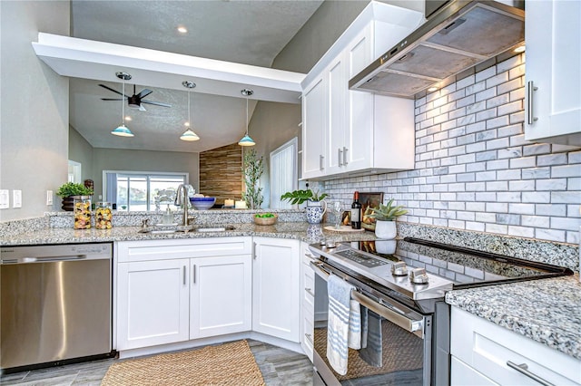 kitchen featuring pendant lighting, white cabinetry, sink, stainless steel appliances, and wall chimney range hood