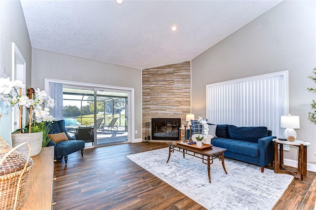 living room featuring a tiled fireplace, high vaulted ceiling, dark hardwood / wood-style floors, and a textured ceiling