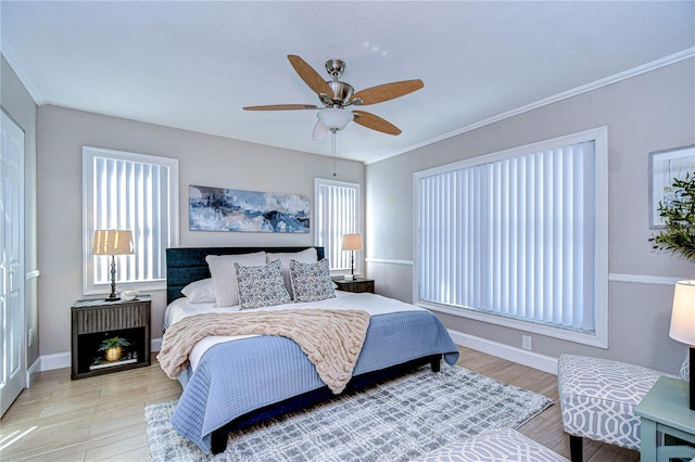 bedroom with ornamental molding, ceiling fan, and light hardwood / wood-style flooring