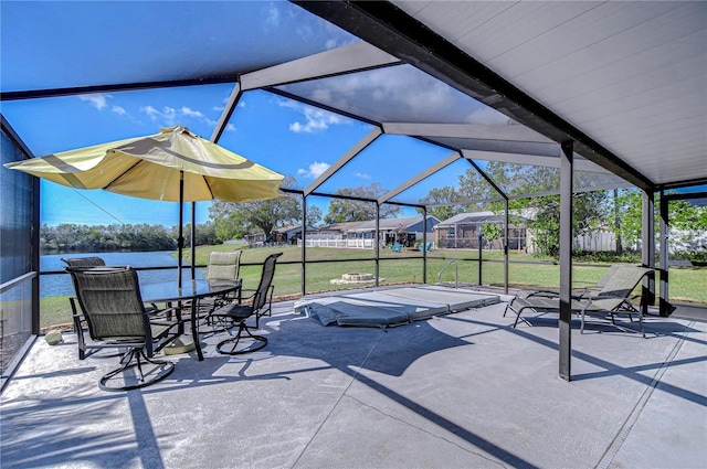 view of patio featuring a water view and glass enclosure