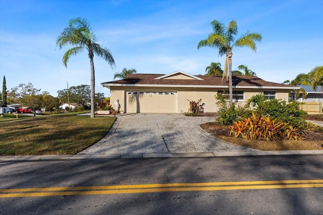 ranch-style home with a garage and a front lawn