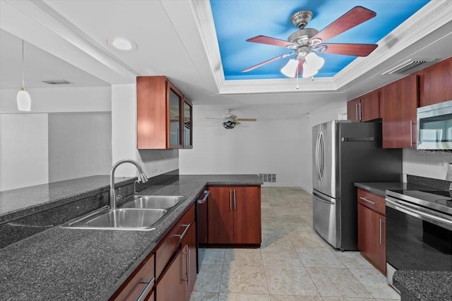 kitchen featuring sink, hanging light fixtures, appliances with stainless steel finishes, a tray ceiling, and kitchen peninsula