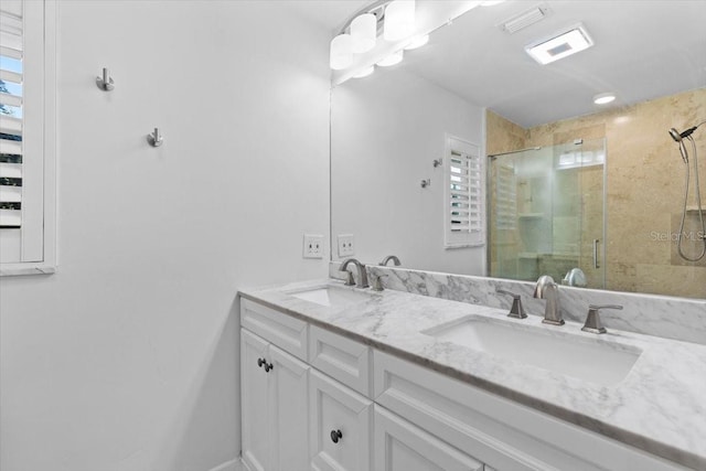 bathroom featuring a shower with door and vanity