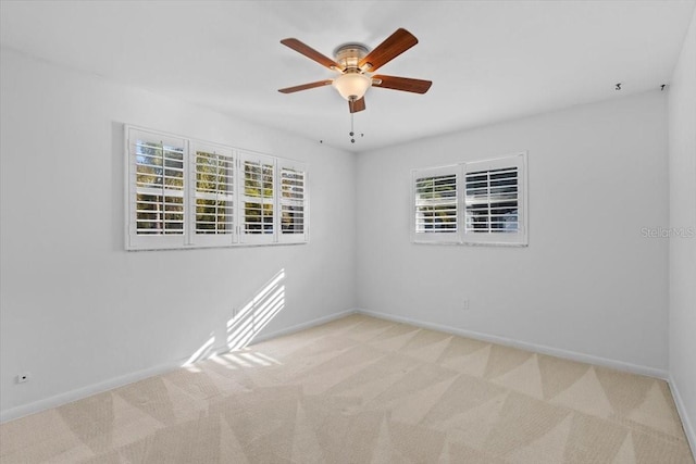 unfurnished room featuring ceiling fan, light colored carpet, and a healthy amount of sunlight