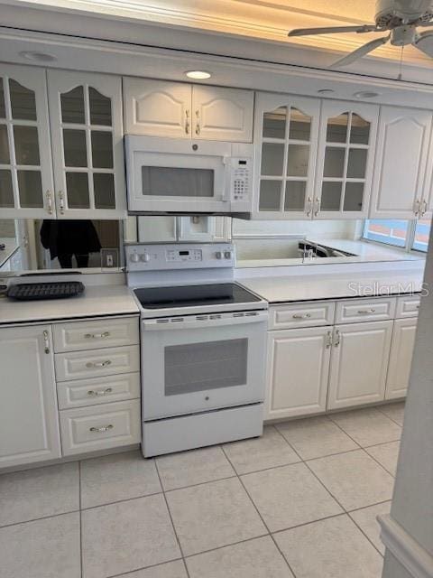 kitchen with light tile patterned flooring, white appliances, ceiling fan, and white cabinets