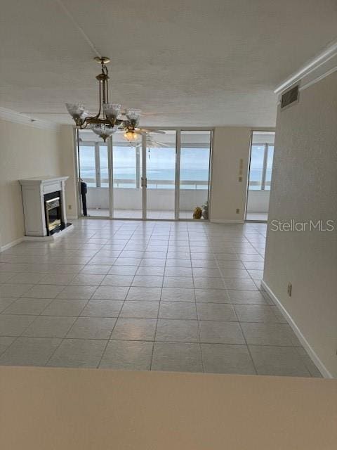 unfurnished living room with light tile patterned floors and an inviting chandelier