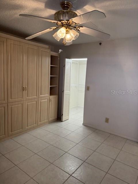 interior space with ceiling fan and a textured ceiling