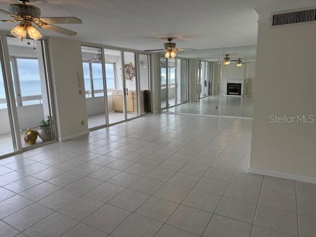 empty room with light tile patterned flooring and ceiling fan