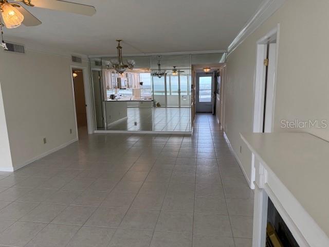 interior space featuring crown molding, tile patterned floors, and ceiling fan