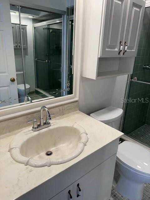 bathroom with an enclosed shower, vanity, and toilet