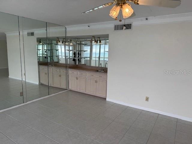 empty room with sink, crown molding, and ceiling fan