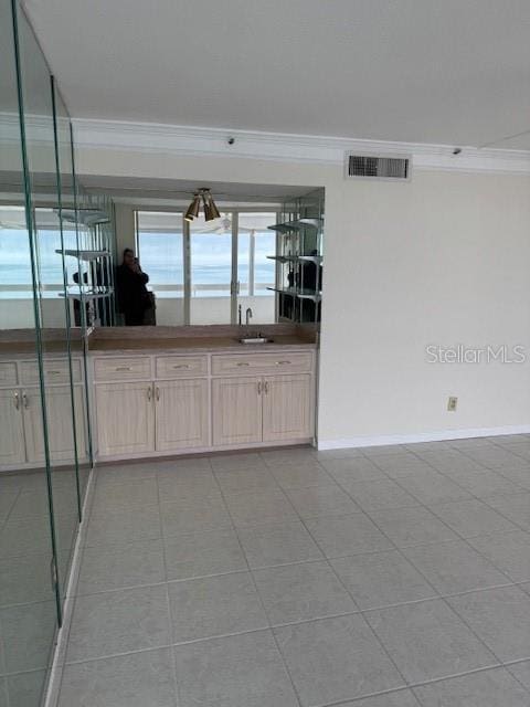 kitchen featuring ornamental molding, sink, light brown cabinets, and light tile patterned floors