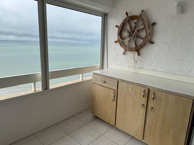 interior space with a water view and tile patterned floors