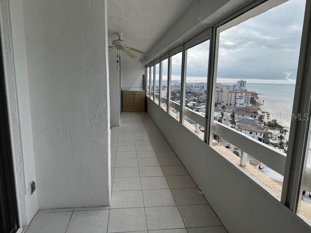 balcony featuring a water view and ceiling fan