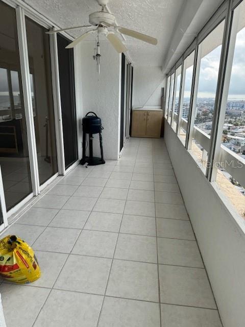 unfurnished sunroom featuring ceiling fan