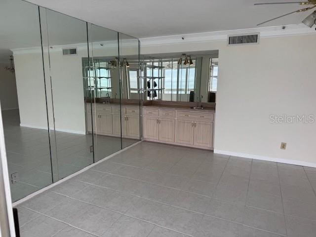 hallway featuring crown molding, sink, and light tile patterned floors