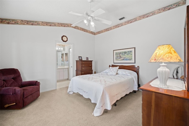 bedroom featuring light carpet, vaulted ceiling, ceiling fan, and ensuite bathroom