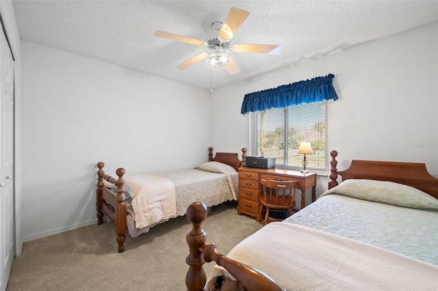 carpeted bedroom with ceiling fan, a closet, and a textured ceiling