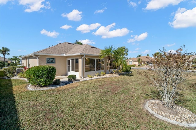 back of house featuring a sunroom and a yard