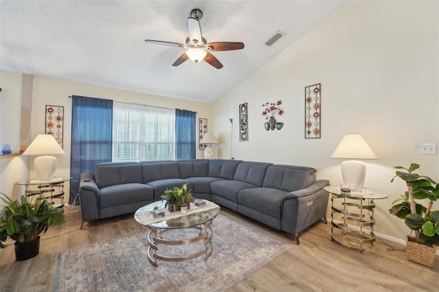 living room with wood-type flooring, lofted ceiling, and ceiling fan