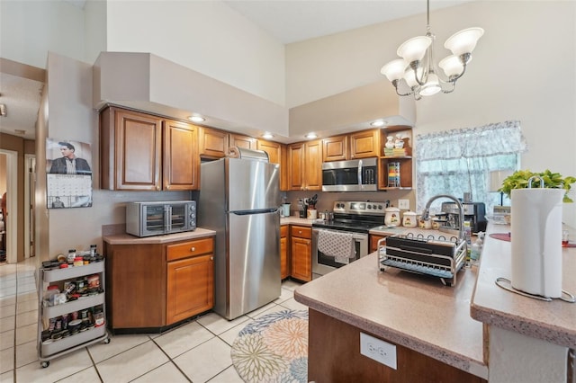 kitchen featuring light tile patterned floors, appliances with stainless steel finishes, hanging light fixtures, a towering ceiling, and a chandelier