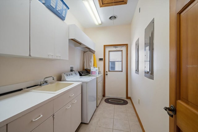 laundry area with cabinets, washing machine and dryer, sink, and light tile patterned floors