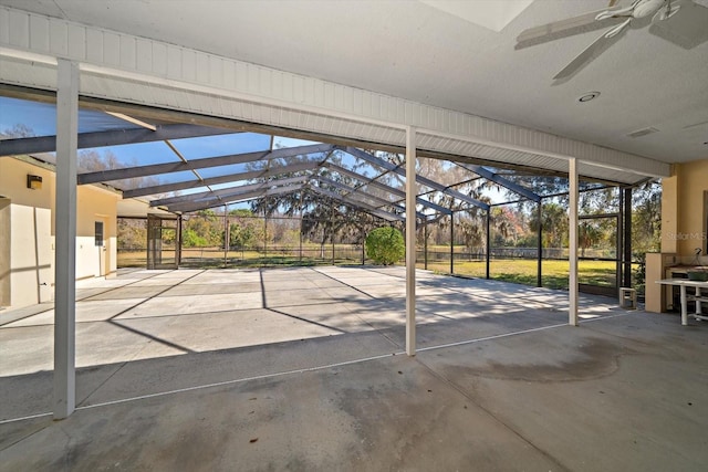 view of patio featuring ceiling fan and glass enclosure